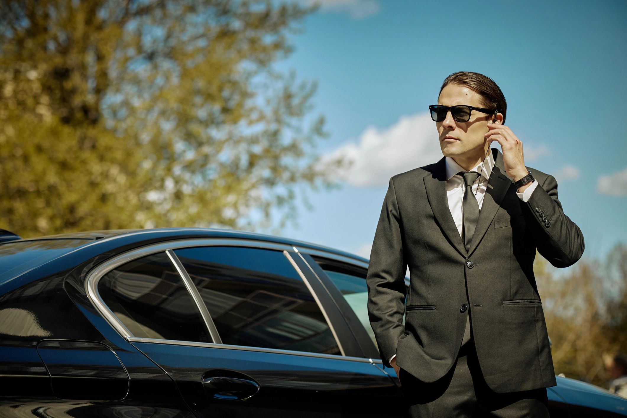 Business traveler beside a premium car